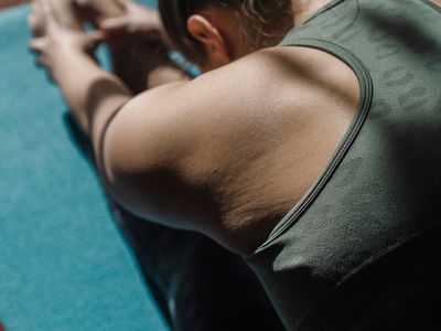 Athlete stretching their legs on a professional yoga mat.