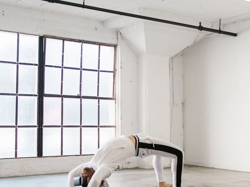 Minimalist yoga studio with dark walls and soft light.